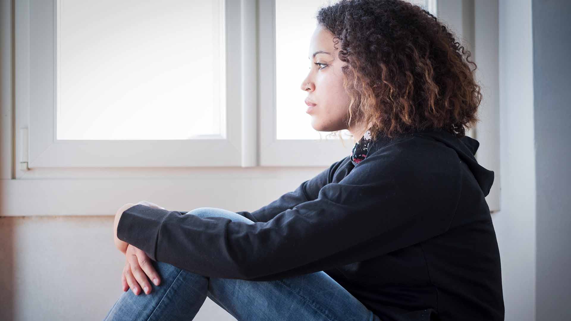 Black woman sitting in PTSD therapy sessions with trauma-focused therapist