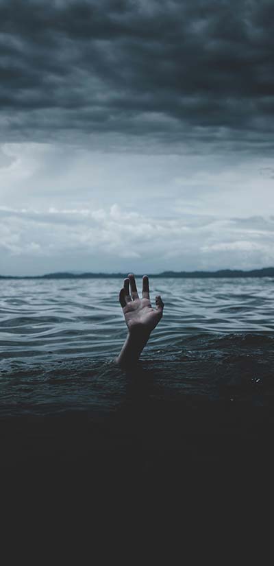 A hand coming out of the stormy ocean symbolizing the overwhelm that can accompany sexual trauma