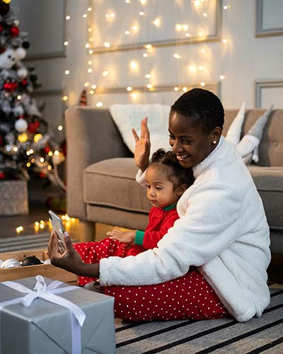 Happy woman and child using a cellphone to contact their support system to help them with setting and maintaining boundaries during the holidays