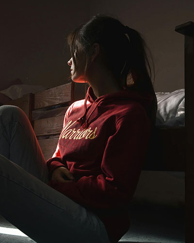 An isolated woman sitting on the floor by her bed after sexual trauma makes it hard for her to form healthy relationships