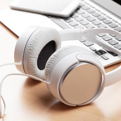 A laptop and headphones on a desk representing the online education for therapists featured on the page