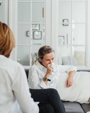 A woman on a therapy couch with tissues feeling exposed durring a session but not healing her repressed trauma A woman on a therapy couch with tissues feeling exposed during a session but not healing her repressed trauma