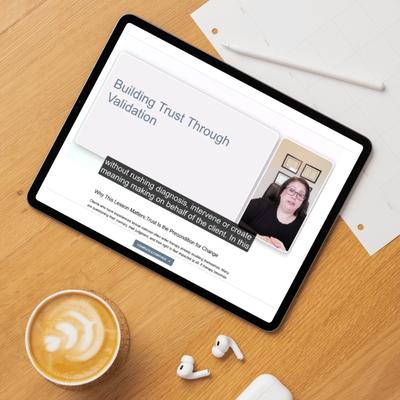 Building Trust Through Validation lesson plays on a tablet beside headphones and a latte