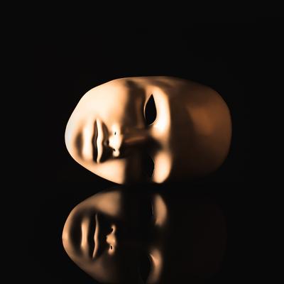 A mask reflecting on a dark surface allude to how a coercive partner can seem to have good character in other contexts